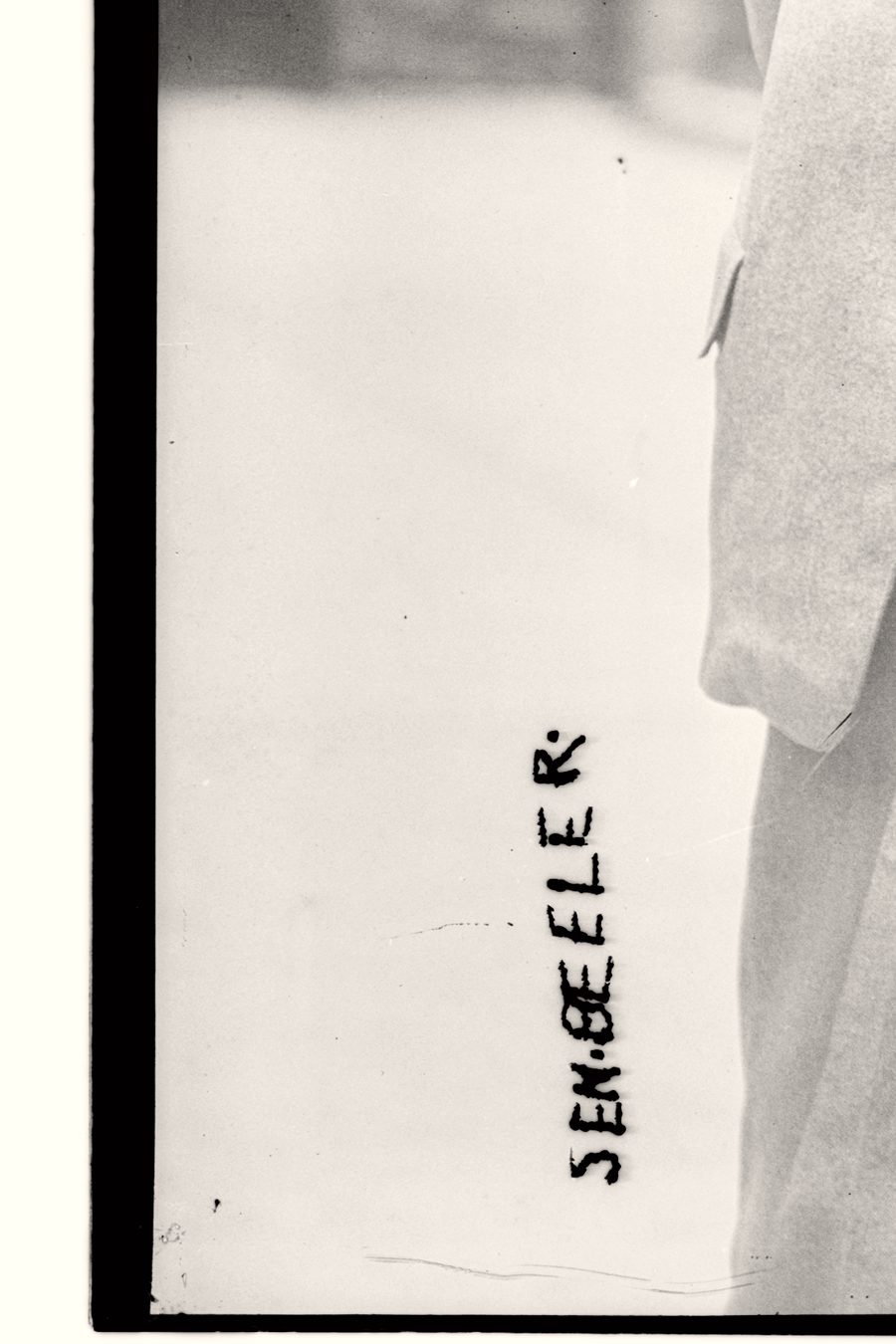 The vertical handwritten name caption Sen. Beeler on the Beeler plate, the source of the exclamation point's dot