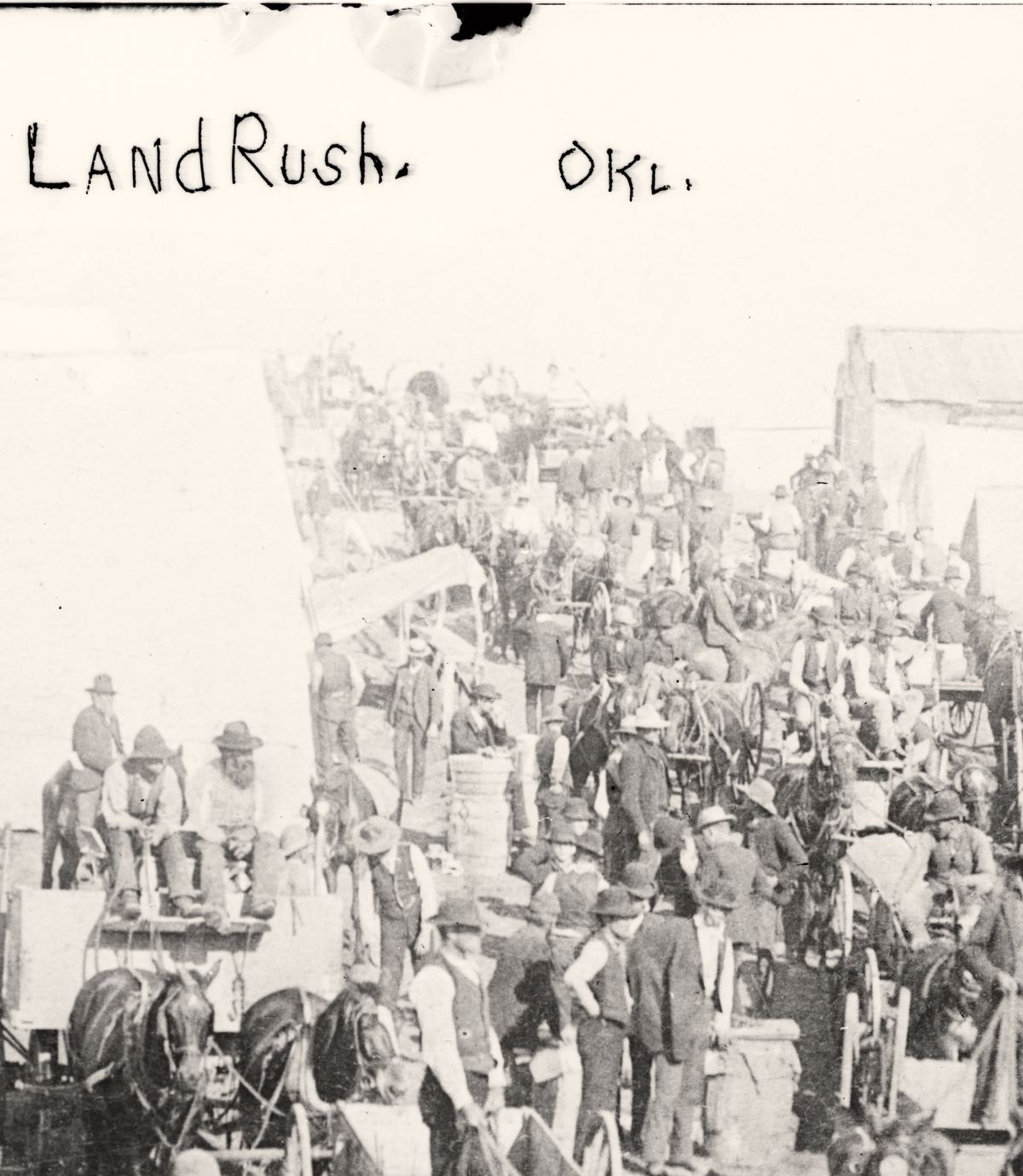 A glass plate negative crop: LandRush. OKL. handwritten in the sky above a land rush tent camp. Library of Congress ggbain.02286.