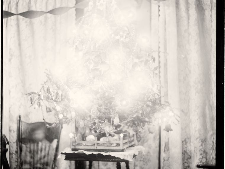 A decorated Christmas tree by a window, Xmas Tree handwritten along the top edge. Library of Congress ggbain.11618.